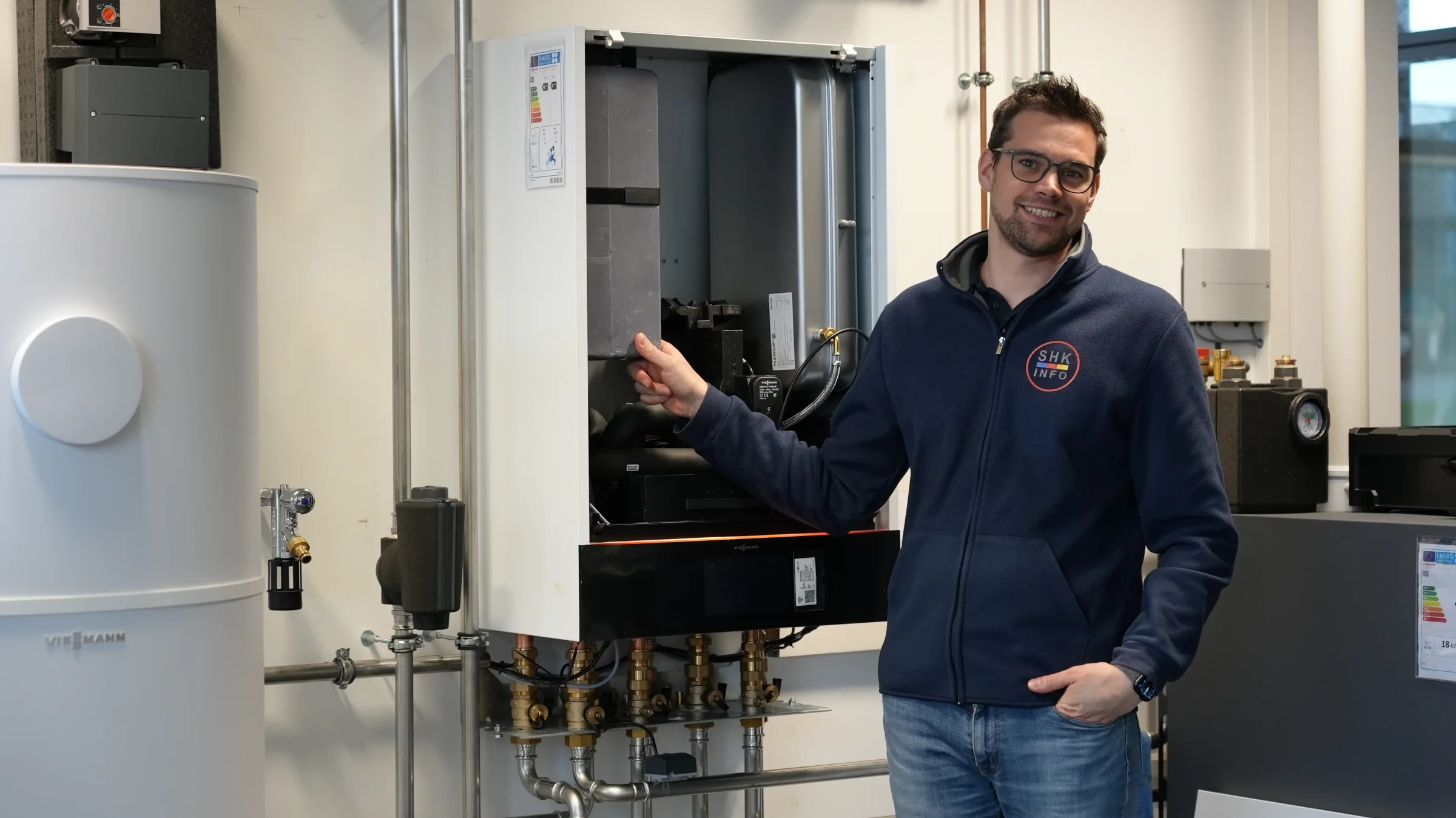 SHK-Fachtrainer an einer geöffneten Wärmepumpenanlage